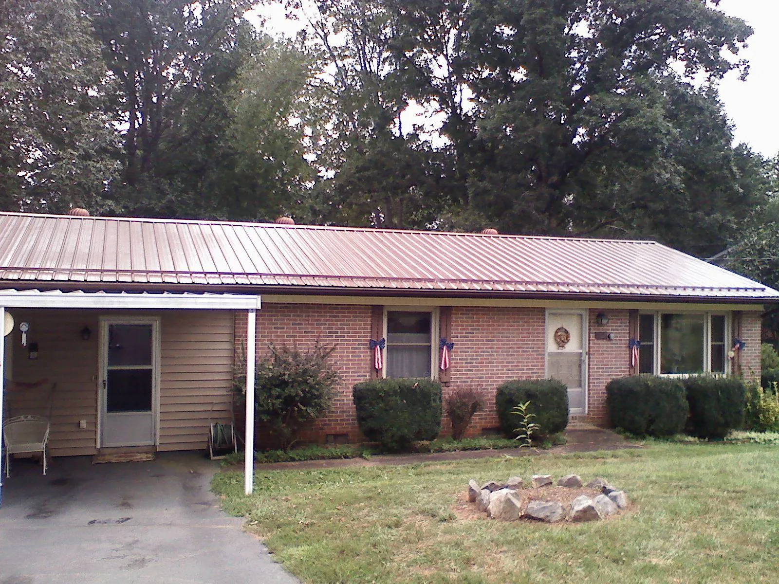 Bronze metal roof and carport on a brick ranch home — Roof Repair work by our crew in Meriden